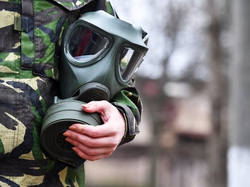 Soldier holding gas mask